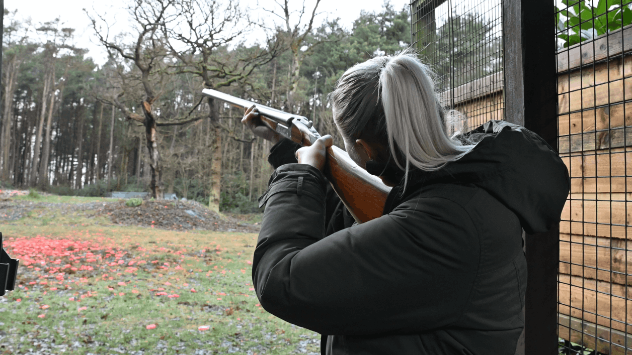 A women having a go at clay pigeon shooting on a corporate day in Manchester   